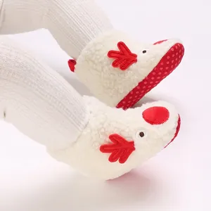 Detalle de botas navideñas de reno para bebé en forro polar blanco con cuernos.