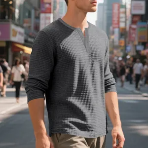 Detalle de camiseta Henley gris para hombre con tejido gofrado y cuello con botones clásicos.