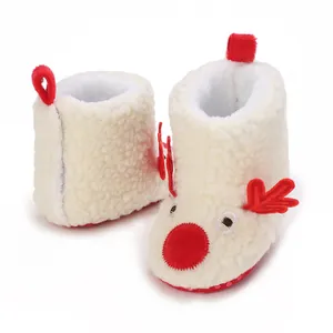 Primer plano de botas de bebé de reno de Navidad de forro polar blanco muy suave