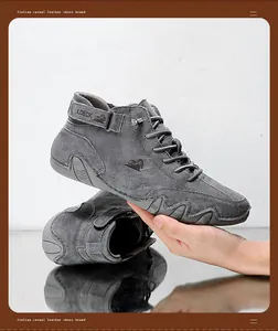 Main tenant des bottines Martin en daim gris montrant le profil et la semelle