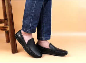 Nahaufnahme von schwarzen Herren-Slippern aus genarbtem Leder mit weichen Sohlen