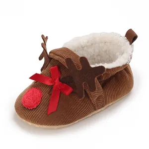 Detail of reindeer-themed baby winter shoe with soft fleece lining and red bow