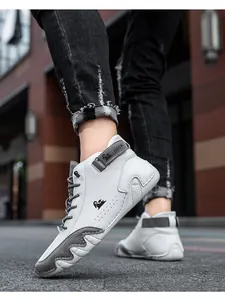 Close-up of stylish white and grey leather high-top Martin boots on urban pavement.