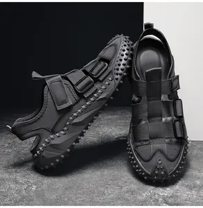 Détail des sandales homme en cuir noir avec semelles robustes à picots.