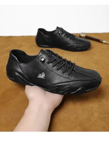 Κοντινό πλάνο μαύρων δερμάτινων casual παπουτσιών με σόλα χταπόδι και μεταλλικό σήμα