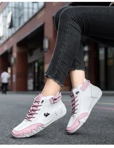 Detailed view of white and pink high-top leather boots in a stylish urban setting