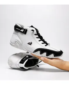 Professional view of high-top leather Martin boot in black and white held by hand.
