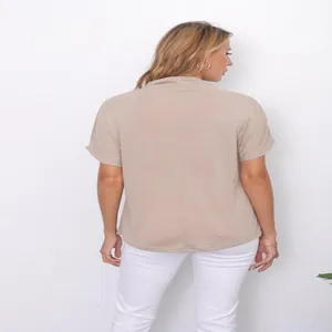 Back view of a relaxed fit beige short sleeve top featuring a half turtleneck design