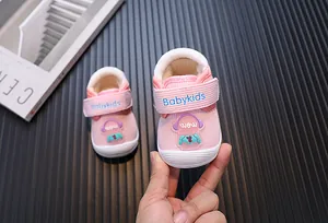 Close-up of pink plush baby walking shoes featuring a cute cartoon astronaut detail.