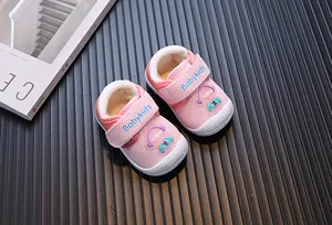 Detail showing pink warm fleece baby walking shoes with cute cartoon figure and velcro