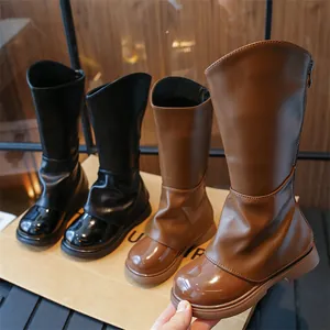 Détail de bottes hautes pour filles avec bouts vernis et fermeture éclair arrière.