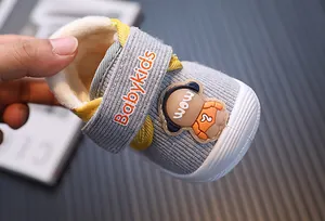Close-up of warm fleece-lined grey baby shoes with cute cartoon character detail