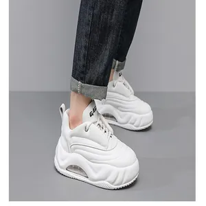 Close-up view of white chunky platform sneakers with visible air cushion sole on model