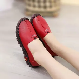 Detailed view of comfortable red leather flat shoes featuring soft soles and heart-shaped detail