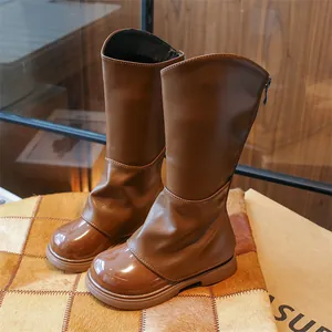 Détail de bottes hautes marron pour filles avec fermeture éclair et bout en cuir verni brillant