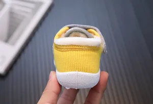 Close-up of the plush warm lining inside a yellow knitted baby walking shoe heel