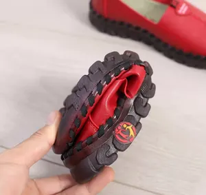 Detail shot showing the high flexibility of red leather mom shoes with soft soles