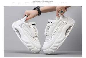 Close-up of white chunky dad shoes with thick air cushion soles held by hands