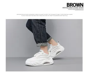 Close-up of white chunky sneakers with visible air cushion sole on grey background.