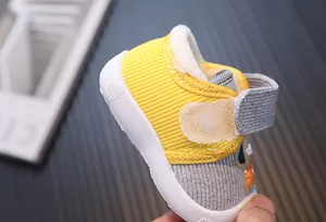 Close-up of warm baby toddler shoe with yellow ribbed fabric and white fleece lining