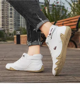 Detailed side view of white high-top men's casual boots with tan textured soles