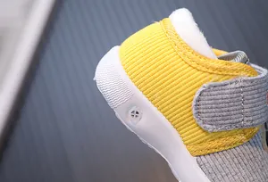 Close-up of the yellow ribbed fabric and white squeaker sole on a warm winter baby shoe.