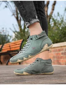 Close-up of men's sage green high-top casual boots with octopus sole on wooden deck
