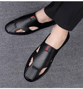 Detail shot of black leather hollow-out men's sandals with iconic red and green stripe