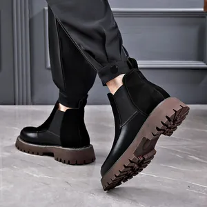 Bottines Chelsea classiques en cuir noir pour hommes avec une semelle crantée marron.