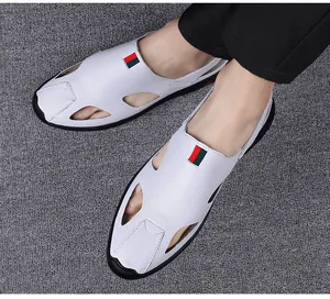 Close-up view of men's white leather cutout sandals with red and green stripe accents