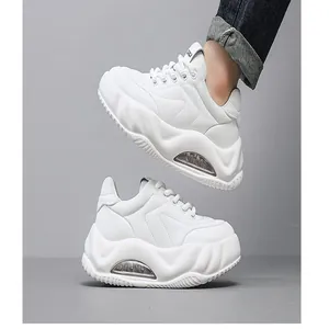 Side view of white chunky sneakers with thick platform soles and clear air cushions.
