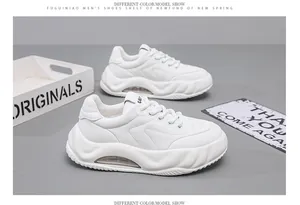 Close-up detail of white chunky men's dad shoes with air cushion sole and textured design.