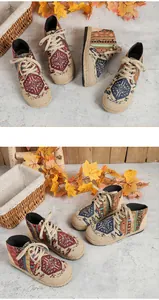 Detailed macro view of vintage ethnic totem patterns on high-top linen canvas shoes.