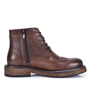 Dettaglio laterale di stivali Martin Brogue in pelle marrone con zip e lacci.