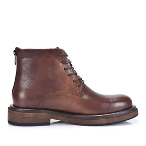Detailed side view showing texture of brown leather men's lace-up boots with thick sole