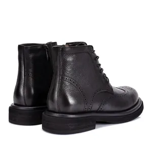 Dettaglio laterale di stivali brogue Martin da uomo in pelle nera con finitura ruvida.