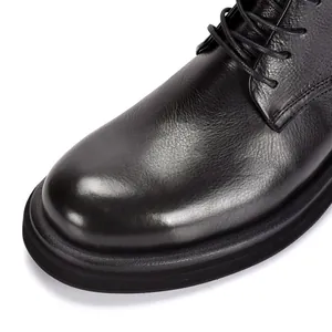 Close-up detail of black leather Martin boots showing round toe and premium texture