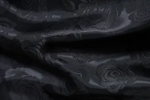 Makro-Detail von hochwertigem schwarzen Rosen-Jacquard-Stoff mit floralem Muster