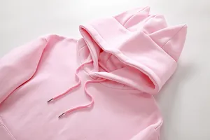 Primer plano de sudadera de forro polar rosa con capucha y diseño de orejas de gato.