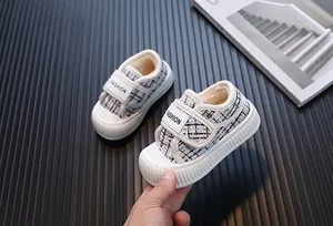 Primo piano di scarpe in tweed per bambini con fodera in pelliccia e chiusura velcro