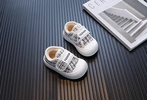 Dettaglio scarpe in cotone tweed per bambini con suole bianche morbide a biscotto