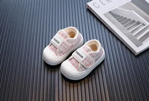 Primo piano di scarpe invernali in tweed rosa per bambine con calda fodera in peluche