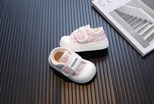 Primo piano di scarpe in tweed rosa per bambini con calda fodera in pelliccia.