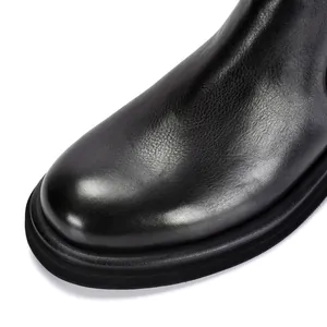 Detailed close-up of a black genuine leather Chelsea boot with thick rubber sole