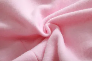 Detalle macro de la suave tela polar rosa que muestra una textura gruesa y cálida