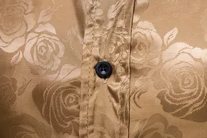 Detailansicht des goldenen Herrenhemds mit Jacquard-Rosenmuster und schwarzem Knopf.
