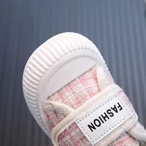 Primo piano di scarpe in tela rosa tweed per bambine con punta bianca e toppa fashion