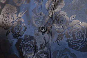 Nahaufnahme eines blauen Herrenhemdes mit aufwendigem Rosen-Jacquard-Muster und Knopf.