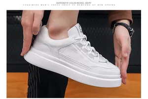Κοντινή λεπτομέρεια από λευκά chunky sneakers με ανάγλυφο δέρμα και σόλα πλατφόρμα.
