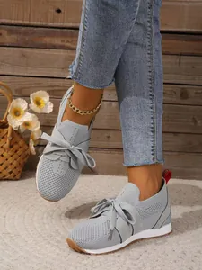 Nahaufnahme der leichten grauen Mesh-Sneaker mit modischer Schnürung und dicker Sohle.